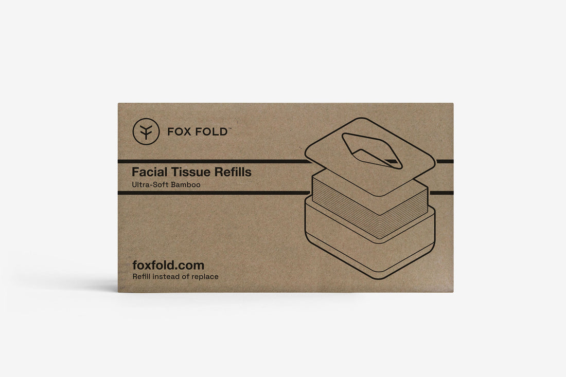 A rectangular brown kraft-paper style box for Fox Fold Facial Tissue Refills, featuring black line art of the tissue stack and product branding on a light gray background.