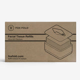 A rectangular brown kraft-paper style box for Fox Fold Facial Tissue Refills, featuring black line art of the tissue stack and product branding on a light gray background.