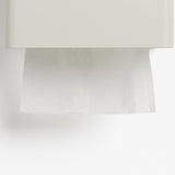 A close-up of a white wall-mounted tissue dispenser with a white tissue paper partially pulled down, set against a clean white background.